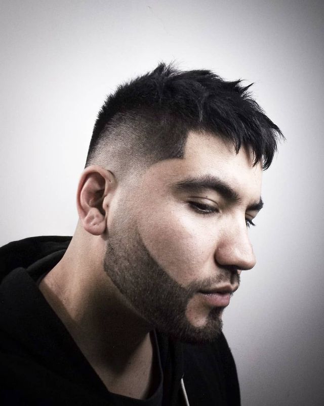 Skin fade with textured spiky top and full beard