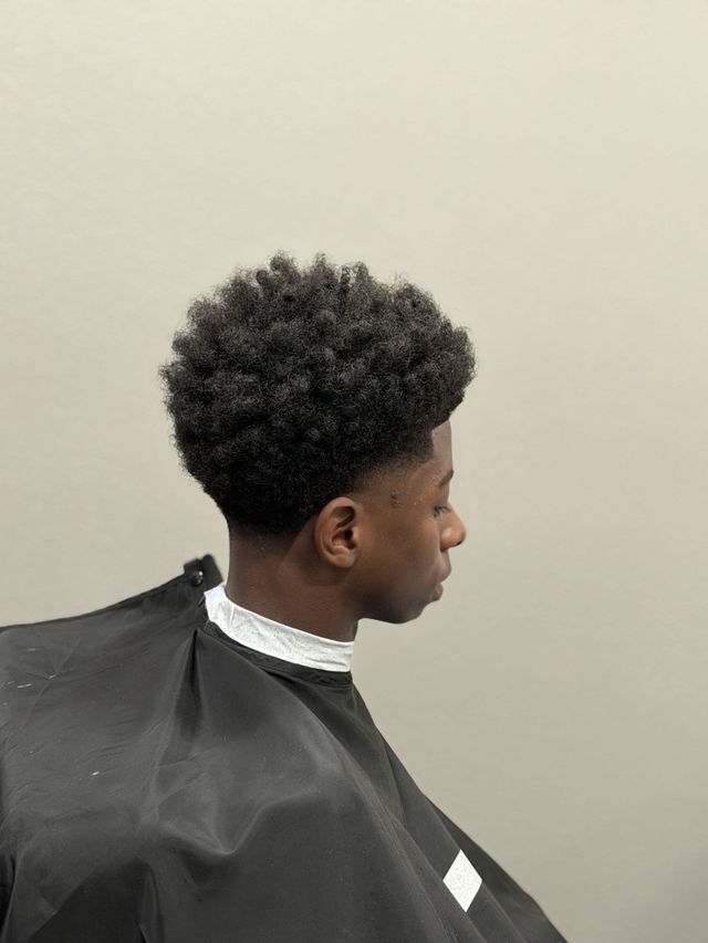 Curly afro fade, back view, client in cape