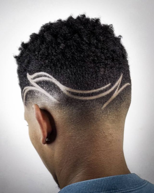 Curly fade with freehand curved line design, back view